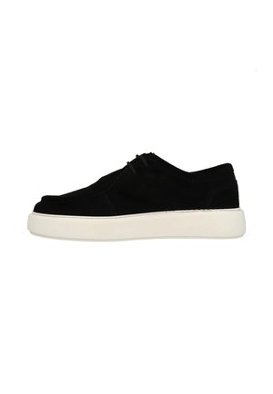 Baskets en suède noir avec un bout arrondi, semelle en caoutchouc blanc et un laçage minimal. Présente une texture lisse et des lignes de design épurées.