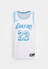 Maglia da basket bianca con accenti blu. Presenta "LAKERS" e "23" in caratteri in grassetto. Realizzata in un materiale leggero e traspirante. Etichetta Nike visibile.