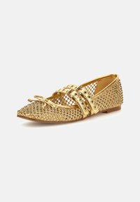 Goldene Ballerinas mit abgerundeter Zehenpartie, die ein Netzdesign, eine genoppte Textur und doppelte Schnallenriemen aufweisen. Glatte Oberfläche und niedriger Absatz.