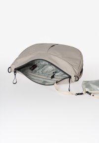 Borsa morbida grigia chiaro con apertura con zip, tasche interne e pochette staccabile. Superficie esterna liscia con un design elegante.