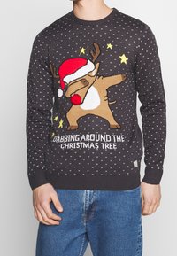 Maglione di Natale grigio scuro con una renna che indossa un cappello rosso da Babbo Natale, in posa dabbing, circondata da stelle e motivi testurizzati.