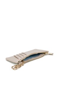 Portafoglio in pelle beige chiaro con chiusura a zip, tre fessure verticali per carte e un attacco per portachiavi in metallo dorato. Interno foderato in blu.