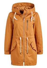Pomarańczowa wodoodporna kurtka z kapturem, sznurkami, frontowym zamkiem błyskawicznym i dwoma bocznymi kieszeniami. Posiada wszytą talię dla regulowanego dopasowania.