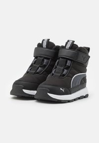 Black nylon and leather boots with a white sole, featuring Velcro straps, a textured upper, and a grey PUMA logo.