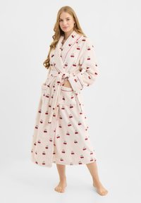 Albornoz de baño rosa claro y esponjoso con estampado de cerezas rojas, cinturón en la cintura, bolsillos laterales y ribete contrastante en los bordes.