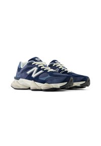 Navy blue athletic shoes with suede and mesh materials, rounded toe, white laces, and beige accents on the sole and midsole.