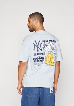 Lys blå bomulds T-shirt med et grafisk design, der viser New York Yankees-logoet, en baseball og en ølkrus på ryggen.