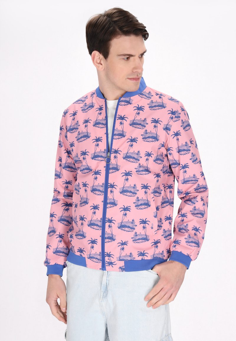 Giacca bomber rosa con stampa di palme blu e isola, chiusura frontale con zip, colletto e polsini a costine, texture morbida, design leggero.