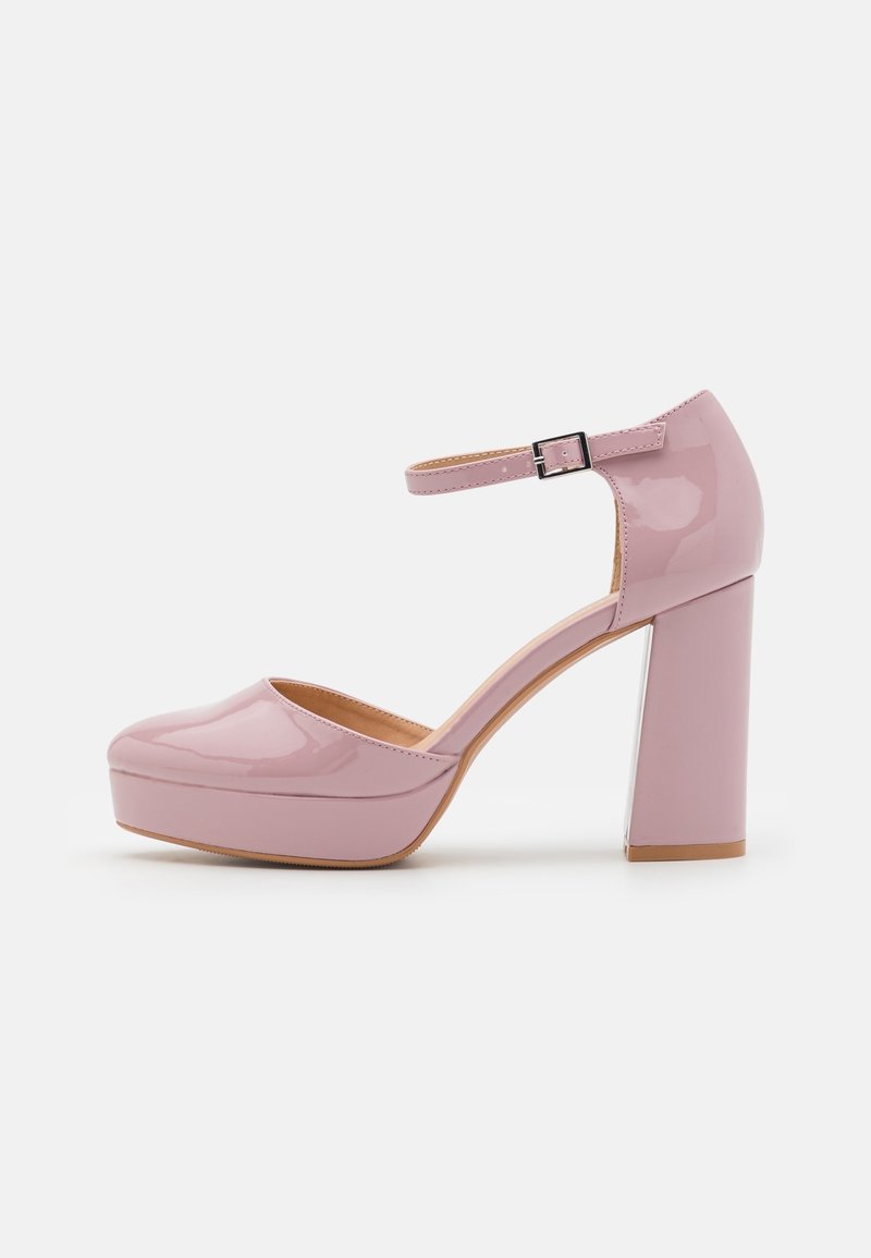 Chaussure à plateforme rose pâle brillante avec bride à la cheville et talon bloc, vue de côté sur un fond blanc uni.