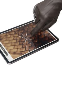 Planšetinis kompiuteris su juodu rėmu, rodančiu tekstūruotą rudą paviršių. Pirštinėmis apsupta ranka bendrauja su ekranu, pabrėždama jutiklinio valdymo funkcijas.