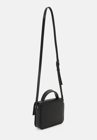 Svart läder crossbody-väska med avtagbar axelrem, rektangulär form, handtag upptill och diskret branding på framsidan.