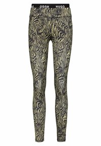 Leggings a strisce zebrate nere e gialle con un cinturino in tessuto HUGO nero, caratterizzati da un design aderente e una texture liscia.