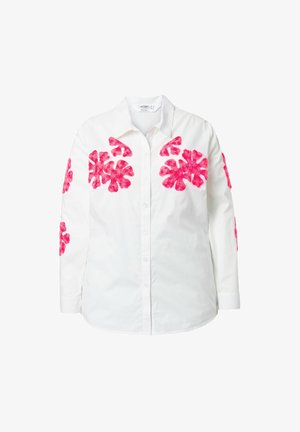 Witte langekleurige shirt met lange mouwen, voorzien van roze bloemenborduurwerk op de schouders en mouwen. Knoopsluiting aan de voorkant met een klassieke kraag.