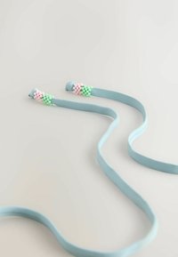 Sangle en tissu bleu clair avec des grappes de perles roses et vertes aux deux extrémités, étalée sur une surface neutre.