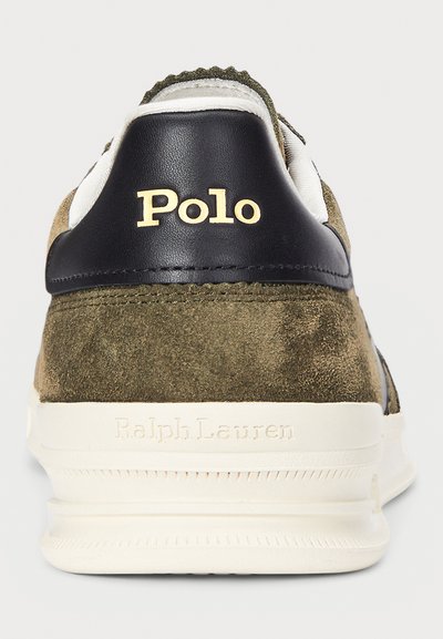 Baskets en daim vert avec des accents en cuir noir. Présente un logo "Polo" en relief doré ainsi que "Ralph Lauren" sur une semelle texturée de couleur crème.