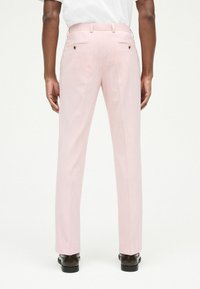 Pantalones ajustados rosa con un corte slim, que presentan una textura suave, dos bolsillos traseros con botones y terminan con un frente plano.