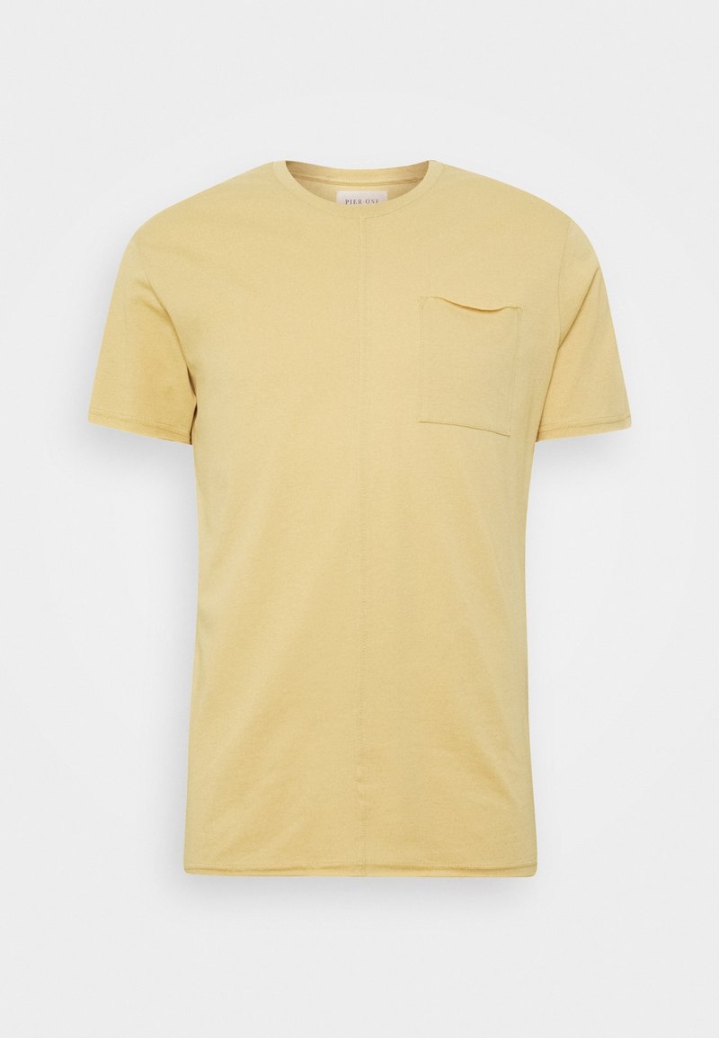 Beżowa męska koszulka z krótkim rękawem, z okrągłym dekoltem i małą kieszonką na lewej stronie.