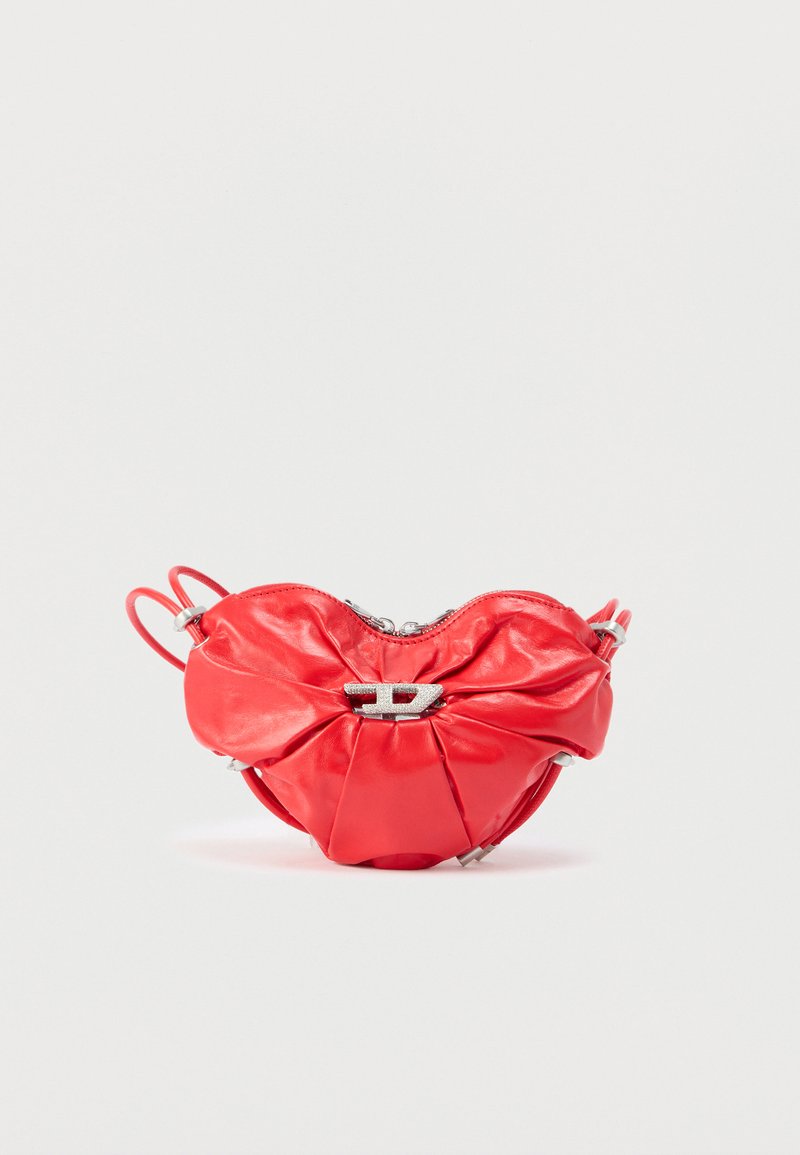 Κόκκινη δερμάτινη τσάντα χειρός με σχήμα καρδιάς, σχεδιασμό με πιέτες, ασημένιο φερμουάρ και έντονο μεταλλικό λογότυπο στο εμπρόσθιο μέρος.