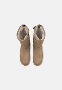 Tansuede kniehohe Stiefel mit Futter aus Kunstfell, seitlichen Reißverschlüssen und runder Zehenpartie. Die Sohle ist strukturiert für besseren Halt.