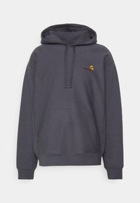 Ciemnoszara bluza z kapturem, z przodem ze kieszenią i sznurkami, z małym żółtym i czerwonym logo Carhartt na piersi.