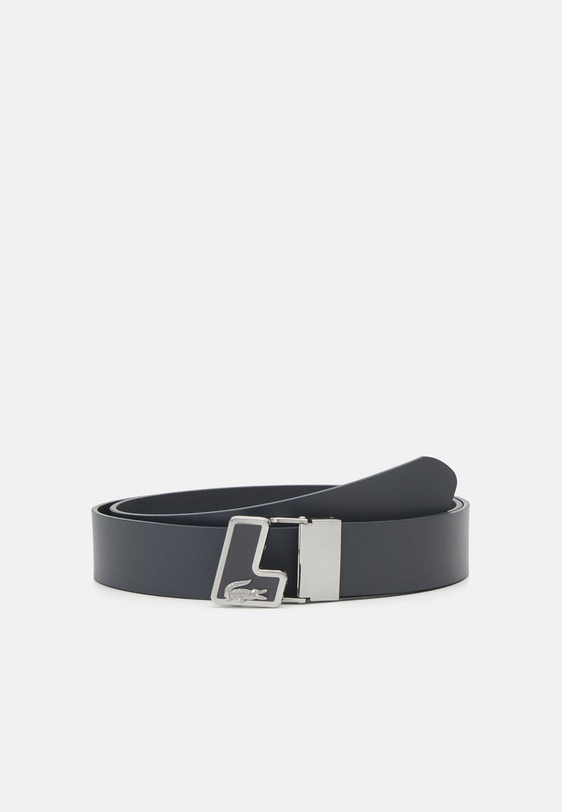 Cinto de couro preto com textura lisa, apresentando uma fivela em metal prateado com um logotipo gravado. Comprimento ajustável, design clássico.