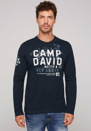Marineblauwe longsleeve shirt met opvallende witte en lichtblauwe tekst. Gemaakt van katoen, heeft een ronde hals en een ontspannen pasvorm.