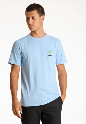 Camiseta de algodón de color azul claro con mangas cortas, que presenta un gráfico de una palmera bordado en el área del pecho izquierdo. Textura suave, escote redondo.