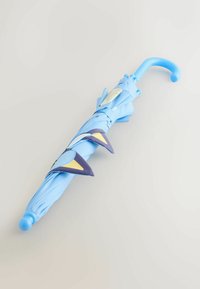 Umbrelă albastru deschis închisă, cu mâner curbat și accente decorative triunghiulare navy și bej de-a lungul părții laterale.