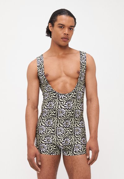 Bañador de diseño escotado con un patrón floral en blanco y verde sobre un fondo negro. Fabricado con un material elástico.