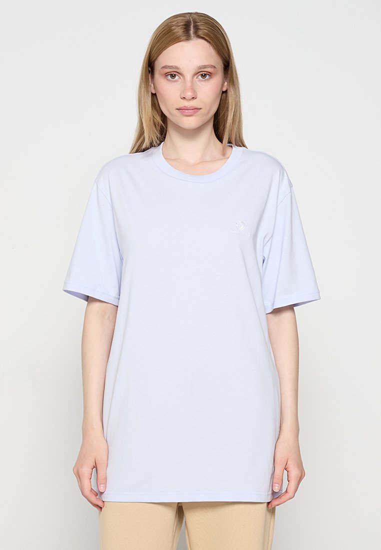 T-shirt oversize en coton violet clair à manches courtes, col rond ribbé et petit logo sur la poitrine gauche.