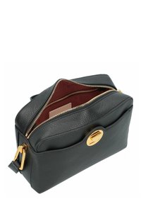 Leren handtas in donkergroen. Voorzien van een rits afsluiting, gouden hardware en een contrasterende rode binnenkant met een open zak.