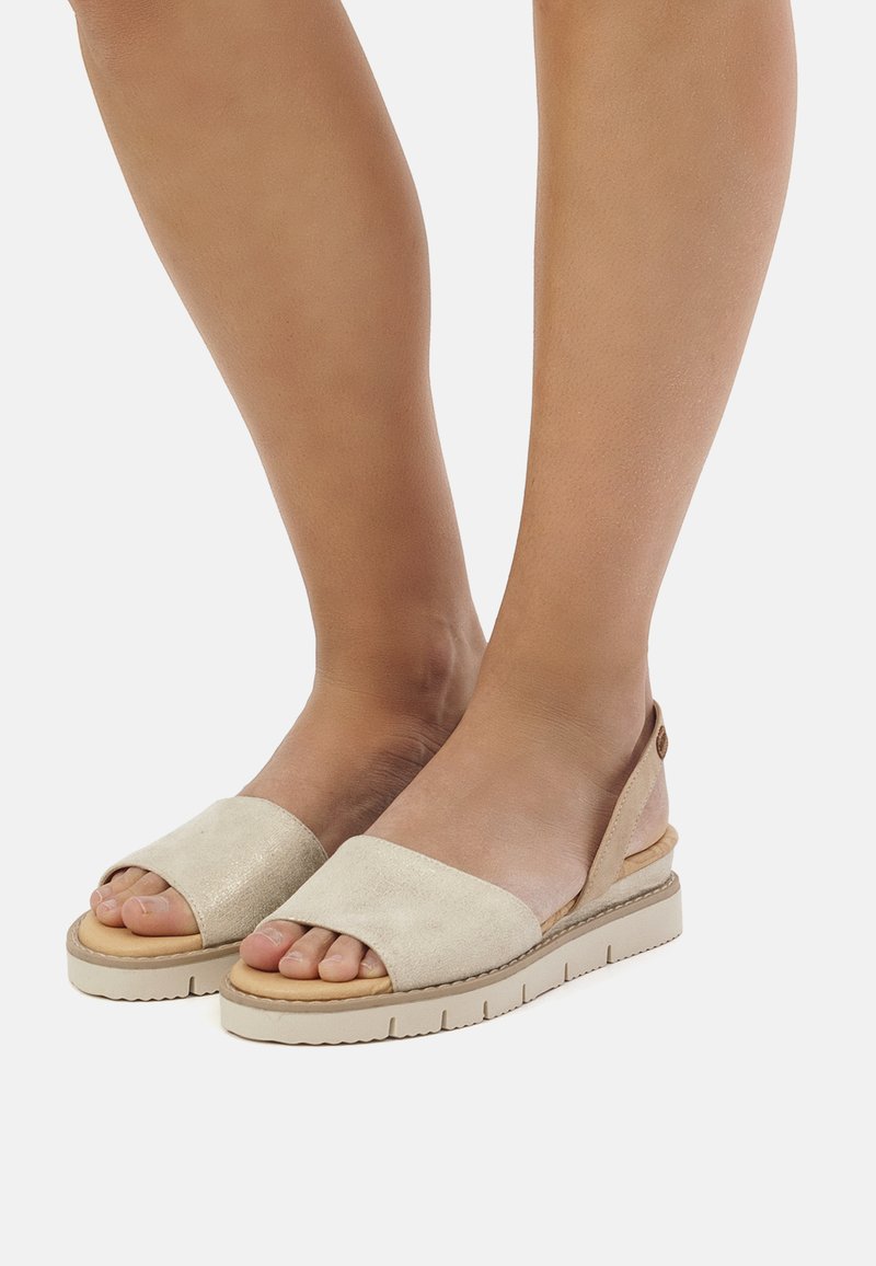 Sandales en daim beige avec bout ouvert, larges brides, dos élastique et semelle plateforme de couleur claire. Semelle extérieure en caoutchouc pour une meilleure traction.
