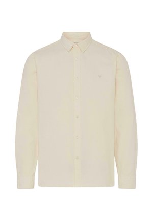 Világos bézs hosszú ujjú gombos ing pamutból, hegyes gallérral, és egy kis hímzett logóval a bal mellen.