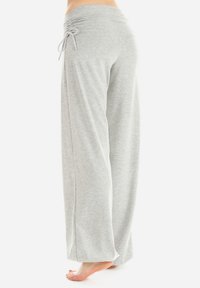 Helle graue weit geschnittene Hose aus weichem Stoff, mit gerafftem Bund und verstellbarem Kordelzug, entworfen für Komfort und Bewegungsfreiheit.