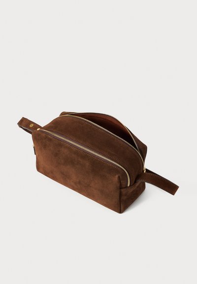 Borsa da toiletta in suede marrone con forma rettangolare, dotata di una cerniera dorata, dettagli in pelle e una maniglia per un facile trasporto.