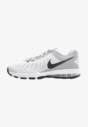 Zapatilla de running Nike en gris claro y blanco con logo Swoosh negro, parte superior de malla, suela acolchada y unidad de aire visible en el talón.