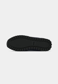 Sole din cauciuc negru cu model de aderentă texturat, având un vârf rotunjit și un design elegant. Logo-ul mărcii este embosat pe lateral.
