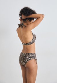 Bikini med leopardmønster som har halterneck med sløyfedetalj og mid-rise truser, laget av et glatt stretchstoff.