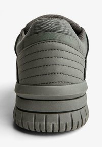 Sivé športové topánky s textúrovaným textilným zvrškom a odpruženou gumovou podrážkou s vzorovaným dezénom a prešívanými detailmi.