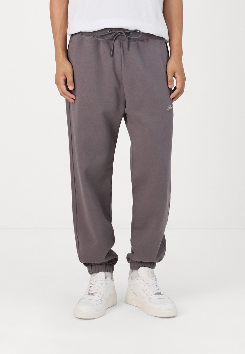 Grå mjukisdbyxor med elastisk midja och benslut, med snöre och sidfickor. Slätt tyg med en subtil brandingdetalj.