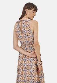 Vestido sin mangas con estampado floral y cintura fruncida, que presenta un detalle de escote en forma de llave y una paleta de colores pastel en durazno y azul.