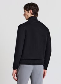 Schwarzer Strickpullover mit hohem Kragen, gerippten Bündchen und Saum. Glatte Textur und taillierte Passform. Rückansicht dargestellt.