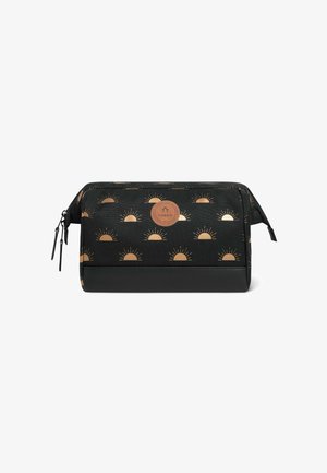 Trousse de maquillage noire ornée d'un motif solaire doré. Le matériau est un tissu avec un accent en cuir à la base. Ouverture zippée et détail de marque.