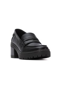 Mocasines de plataforma de cuero negro con acentos cosidos, puntera redondeada y tacón grueso. Suela de goma texturizada para agarre y estabilidad.