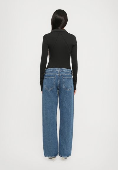 Black long-sleeve bodysuit with a collared neckline, paired with wide-leg blue denim jeans featuring rear pockets and a relaxed fit.