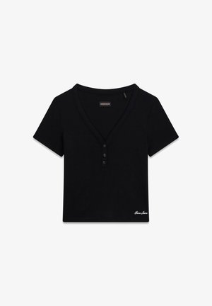 Top corto nero a maniche corte stile Henley con scollo a V, tre bottoni e logo "Guess Jeans" ricamato in basso a destra.