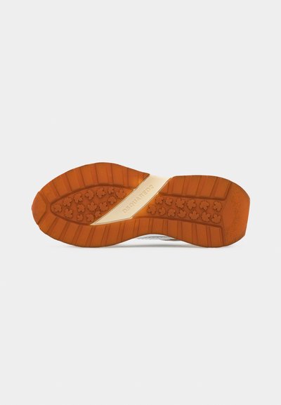 Semelle d'une chaussure de sport avec un motif en caoutchouc marron présentant des feuilles d'érable et une bande beige marquée "DSQUARED2" au centre.