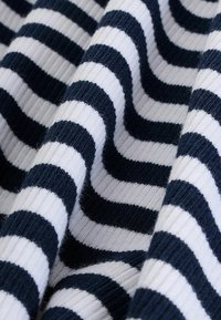 Tissu tricoté à rayures bleu marine et blanches, présentant des rayures épaisses et fines alternées avec une surface texturée en côtes.