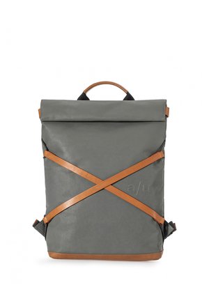 Grauer Rucksack mit Klappe, mit überkreuzten hellbraunen Leder-Riemen auf der Vorderseite und hellbraunem Griff, eingeprägtes "a/u" Logo auf der unteren rechten Seite.