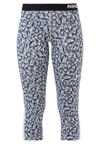 Leggings de sport gris et noir à motif abstrait avec ceinture noire et logo blanc Nike sur la cuisse gauche.